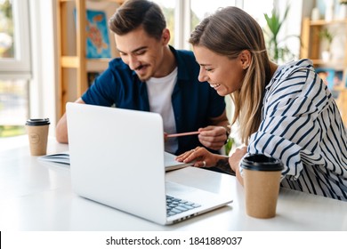 Young caucasian man and woman studying with laptop while sitting at table in classroom - Shutterstock ID 1841889037