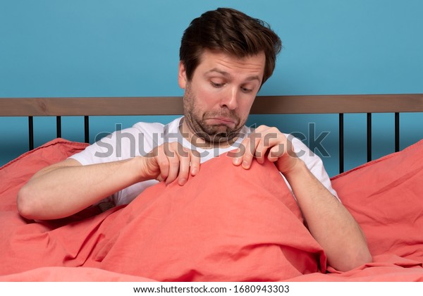 Young\
caucasian man worrying about his penis and erection failure ,\
Surprised young man having trouble with\
potency.