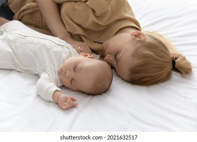 Young Caucasian Mother And Little Baby Infant Kid Child Lying Sleeping Together In Cozy White Bed At Home. Loving Mom And Small Newborn Daughter Or Son Take Nap Fall Asleep. Parenthood Concept.