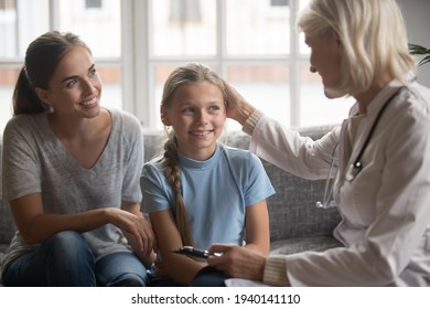 Young Caucasian Mother And Small Teen Daughter Visit Female GP Or Doctor For Health Checkup. Caring Woman Nurse Or Therapist Comfort Little Girl Child Patient At Examination In Hospital Or Clinic.