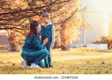 A Young Caucasian Mother Spends Time With Her Son In An Autumn Park. Copy Space.