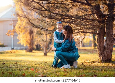 A Young Caucasian Mother Spends Time With Her Son In An Autumn Park. Copy Space. Concept Of Happy Family.