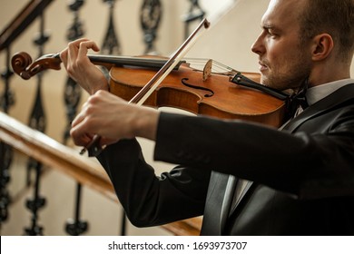 young caucasian musician violinist perform music in the hall before concert, practice playing violin. classical instruments, music concept