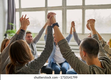 young caucasian people celebrating recovery from alcohol addiction, team work of anonymous addicts club, raised hands up together - Shutterstock ID 1710141799