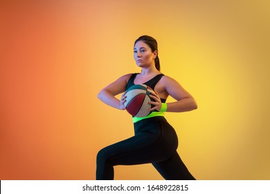 Young Caucasian Plus Size Female Model's Training On Gradient Orange Background In Neon Light. Doing Workout Exercises With Ball. Concept Of Sport, Healthy Lifestyle, Body Positive, Equality.