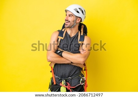 Young caucasian rock climber man isolated on yellow background happy and smiling
