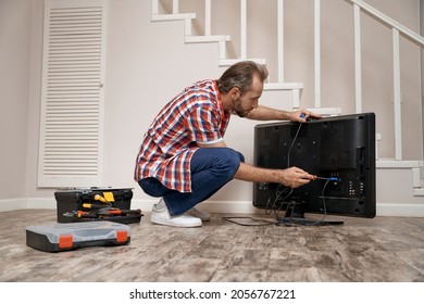 Young Caucasian Service Man Fixing Tv Set