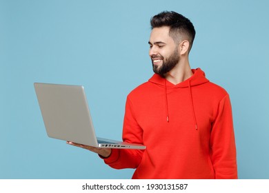 Young caucasian smiling happy copywriter freelancer student bearded man 20s wear casual red orange hoodie hold laptop pc computer isolated on blue background studio portrait Modern technology concept - Powered by Shutterstock