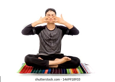 A Young Caucasian Teenager Wearing Activewear Pants And Black Colored T-shirt And Performing Bhramari Pranayama Or Human Humming Bee Breathing Exercise Yoga Isolated On White.On Colorful Yoga Mat.