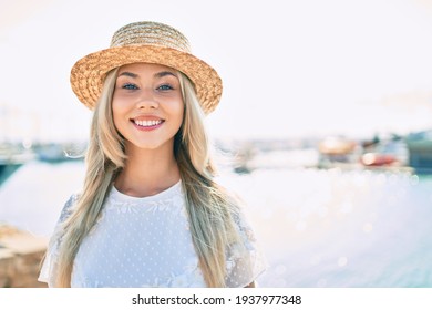 Young caucasian tourist girl smiling happy standing at the river.