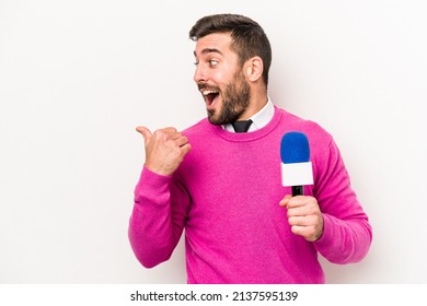 Young caucasian tv presenter man isolated on white background points with thumb finger away, laughing and carefree. - Shutterstock ID 2137595139