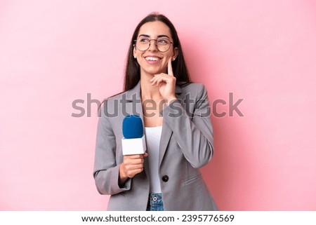 Young caucasian tv presenter woman isolated on pink background thinking an idea while looking up