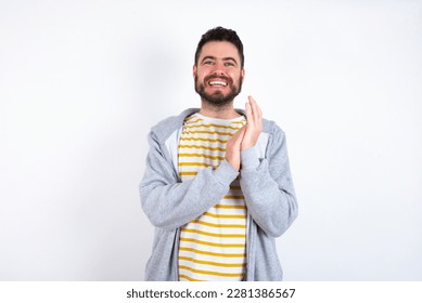 Young caucasian mán wearing trendy clothes over white background clapping and applauding happy and joyful, smiling proud hands together. - Shutterstock ID 2281386567