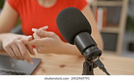 A young caucasian woman with blonde hair speaking in a radio studio, portrayed from the perspective of the microphone. - Powered by Shutterstock