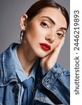 A young Caucasian woman with brunette hair in a denim jacket and vibrant red lipstick exudes confidence and style.