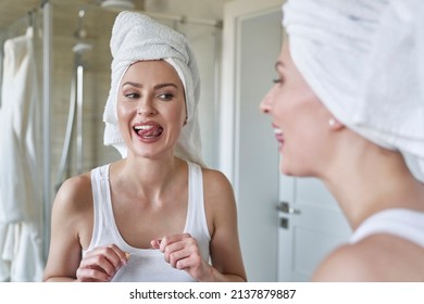 Young Caucasian Woman Checking Teeth After Flossing