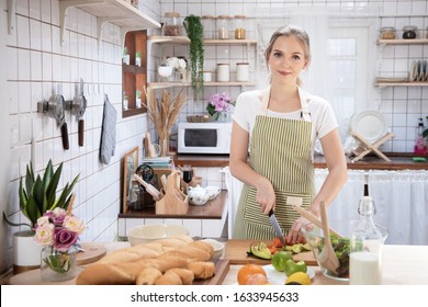 Young caucasian woman cooking food in the kitchen. Healthy food and dieting concept. healthy lifestyle.Teenager housewife cooking at home. 