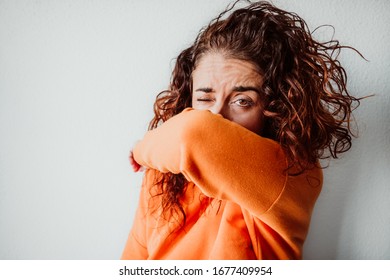 Young caucasian woman with coronavirus symptoms coughing correctly on her elbow. Global health crisis. Pandemia - Powered by Shutterstock