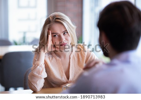 Young Caucasian woman disinterested in blind date, feeling bored with conversation at city cafe. Millennial couple having relationship problems, going through breakup or divorce Сток-фото © 