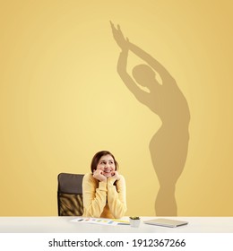 Young Caucasian Woman Dreaming About Future In Big Sport During Her Work In Office. Shadow, Silhouette Of Female Ballet Dancer On The Wall. Becoming A Legend. Inspiration, Aspiration. Copyspace.