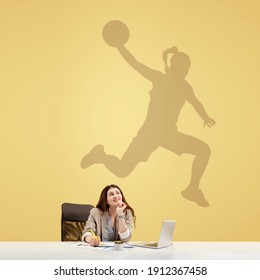 Young Caucasian Woman Dreaming About Future In Big Sport During Her Work In Office. Shadow, Silhouette Of Female Basketball Player On The Wall. Becoming A Legend. Inspiration, Aspiration. Copyspace.