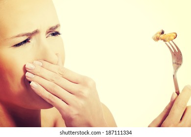 Young Caucasian Woman Eating Seafood With Disguise. 