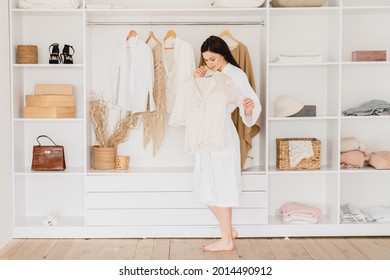 Young Caucasian Woman Girl Choosing New Outfit Look Changing Clothes In The Dressing Room At Home. Morning Preparations. Girl Preparing For Date, Work, Trying On New Clothes