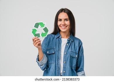 Young caucasian woman girl eco-activist holding recycling logo sign for sorting garbage paper plastic, environmental conservation saving planet from contamination, renewable energy sources