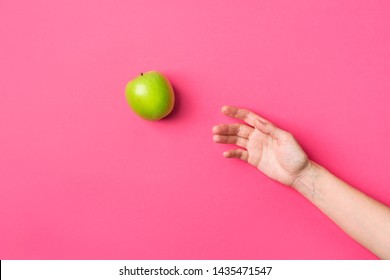 Young Caucasian Woman Girl Reaching For Raw Green Organic Apple On Fuchsia Pink Background. Healthy Plant Based Diet Vitamins Detox Vegan Concept. Trendy Funky Poster With Copy Space