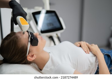Young caucasian woman in goggles on photorejuvenation procedure. Portrait of a girl in a beautician's clinic. - Shutterstock ID 2187274489