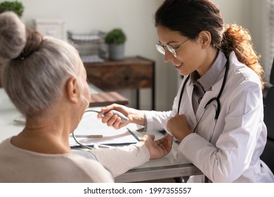 Young Caucasian Woman GP Or Nurse Hold Tonometer Measure High Low Blood Pressure Of Old Patient In Hospital. Female Doctor Check Examine Do Checkup Of Mature Client. Healthcare, Medicine Concept.