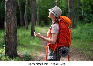 Young Caucasian Woman Is Hiking And Using A Compass In The Forest.