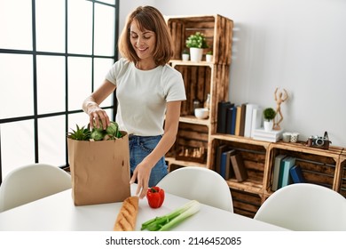 Young Caucasian Woman Holding Food Of Groceries Paper Bag At Home