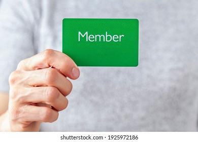 A young caucasian woman is holding a green card that says member on it. A customizable image which has space for text to be inserted. Being a member, membership dues, subscription, group concepts.