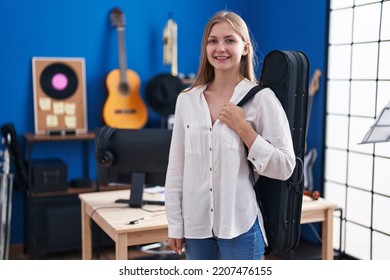 Young Caucasian Woman Holding Guitar Case Looking Positive And Happy Standing And Smiling With A Confident Smile Showing Teeth 