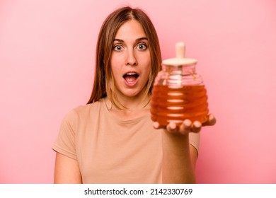 Young Caucasian Woman Holding Honey Isolated On Pink Background