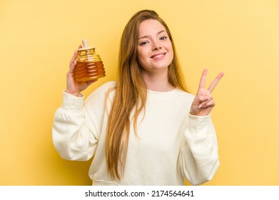 Young Caucasian Woman Holding A Honey Isolated On Yellow Background Showing Number Two With Fingers.