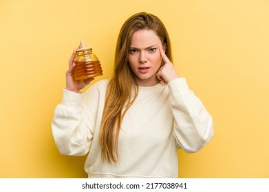 Young Caucasian Woman Holding A Honey Isolated On Yellow Background Showing A Disappointment Gesture With Forefinger.