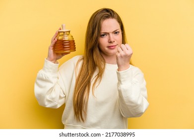 Young Caucasian Woman Holding A Honey Isolated On Yellow Background Showing Fist To Camera, Aggressive Facial Expression.