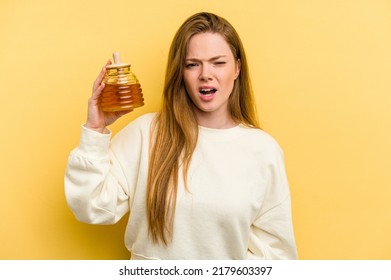 Young Caucasian Woman Holding A Honey Isolated On Yellow Background Screaming Very Angry And Aggressive.