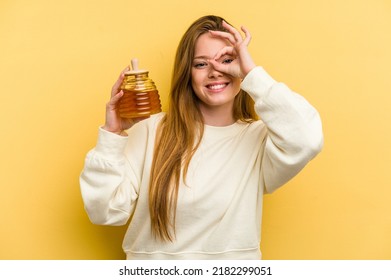 Young Caucasian Woman Holding A Honey Isolated On Yellow Background Excited Keeping Ok Gesture On Eye.