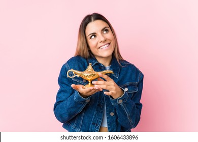 Young Caucasian Woman Holding A Magic Lamp Isolated