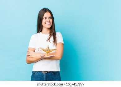 Young Caucasian Woman Holding A Magic Lamp Smiling Confident With Crossed Arms.