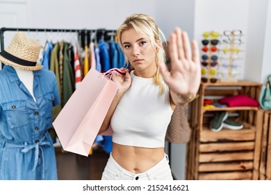 Young Caucasian Woman Holding Shopping Bags At Retail Shop Doing Stop Sing With Palm Of The Hand. Warning Expression With Negative And Serious Gesture On The Face. 