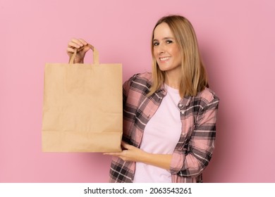 Young Caucasian Woman Holding Take Away Paper Bag Smiling Happy In Pink Background