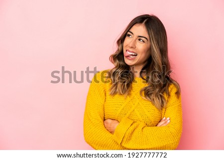Young caucasian woman isolated funny and friendly sticking out tongue.