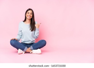 Young Caucasian Woman Isolated On Pink Background Pointing To The Side To Present A Product