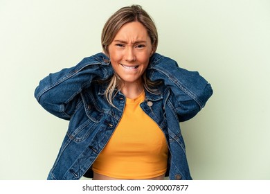 Young caucasian woman isolated on green background screaming with rage. - Shutterstock ID 2090007877
