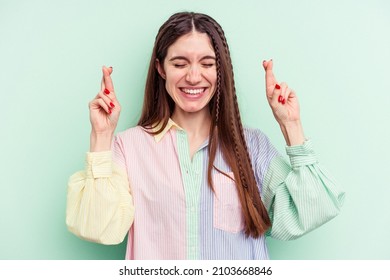 Young Caucasian Woman Isolated On Green Background Crossing Fingers For Having Luck