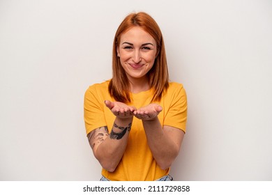 Young Caucasian Woman Isolated On White Background Holding Something With Palms, Offering To Camera.